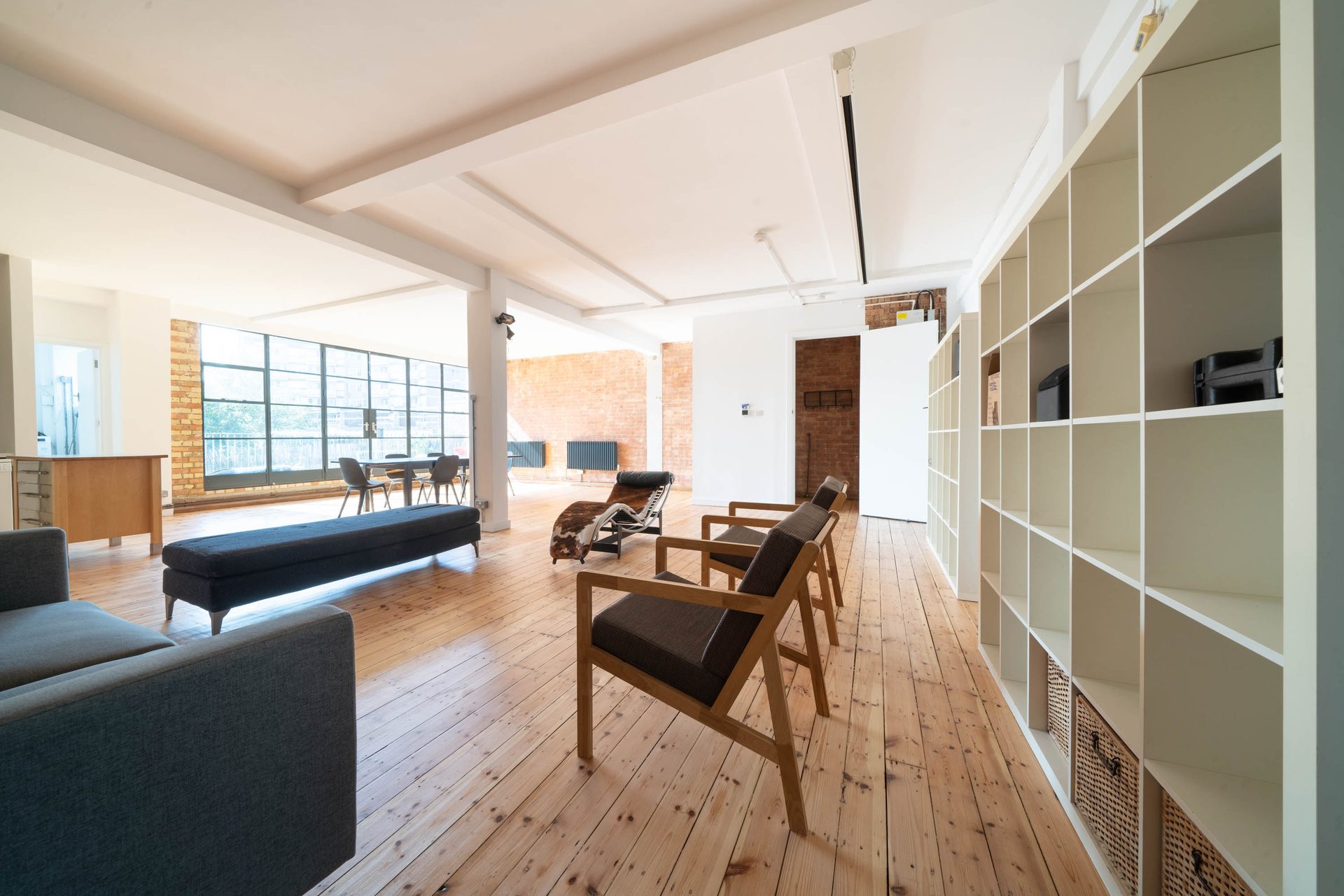 Open-plan reception, kitchen and dining room at Flat 5, Cavell House, showing exposed brick, timber floors and broad industrial-style glazing