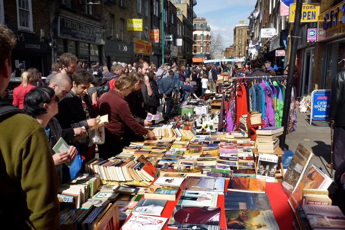 A street vendor and visitors at Brick Lane Market in East London.